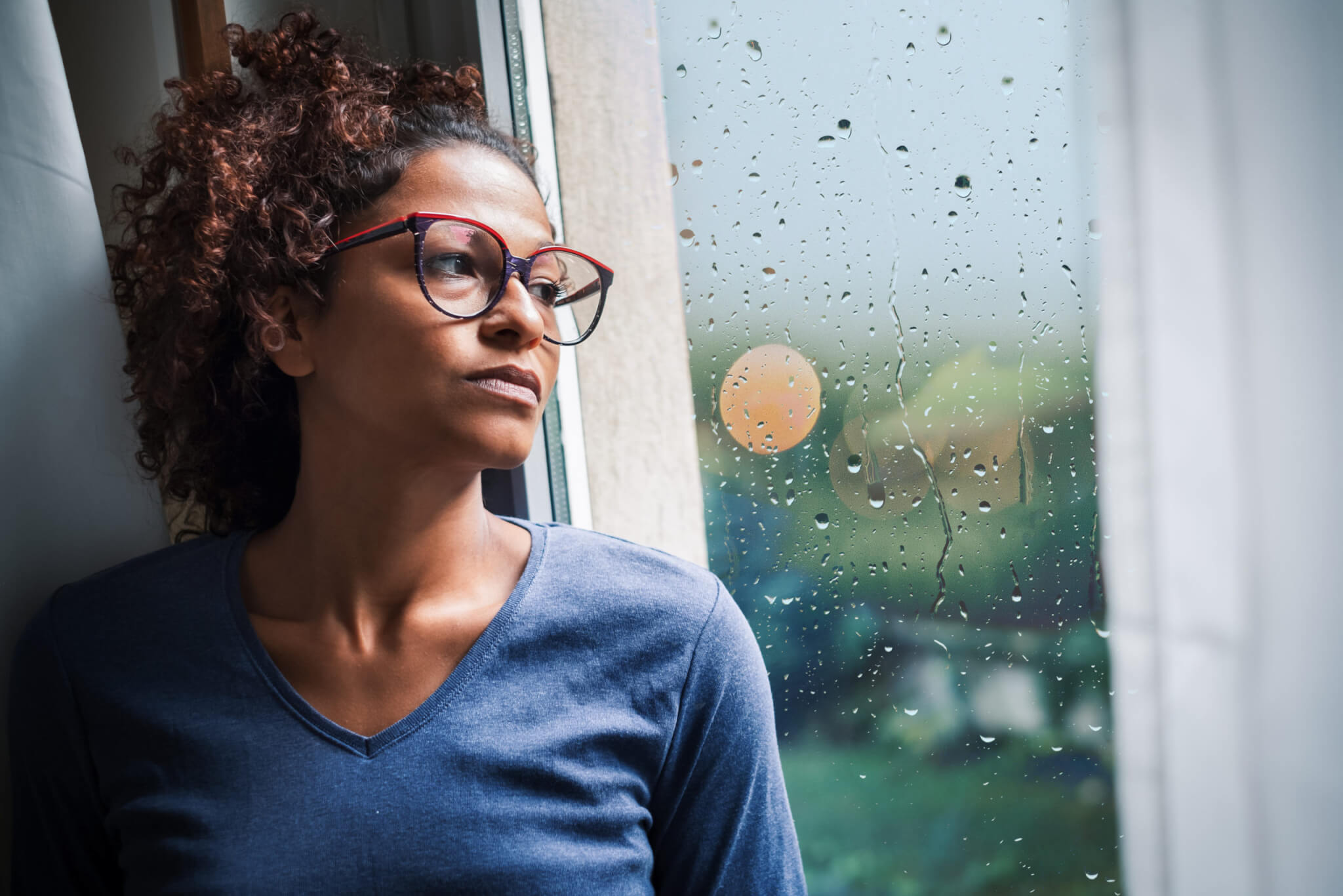 Lonely black woman near window thinking about something